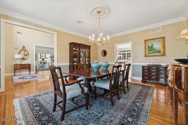 9 Wide Horizons Dr, Colts Neck, NJ 07722 - dining room featuring a chandelier, crown molding, wood finished floors, wallpapered walls, and a wainscoted wall