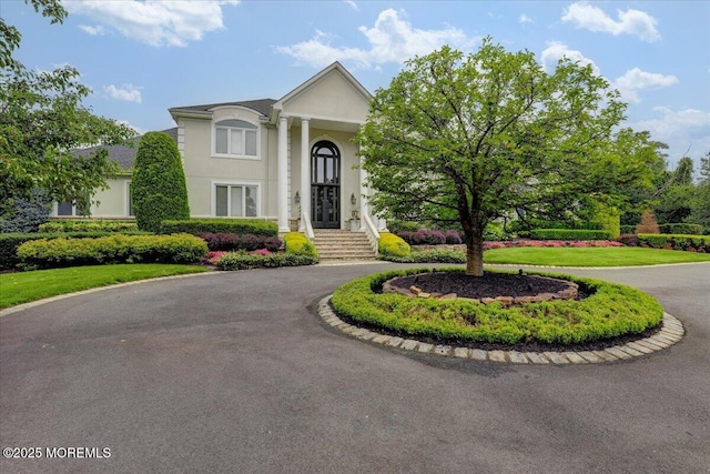 7 Rancho Polo, Colts Neck, NJ 07722 - greek revival inspired property with curved driveway, stucco siding, and a front lawn