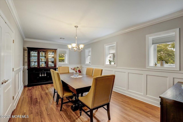 7 Rancho Polo, Colts Neck, NJ 07722 - dining room with healthy amount of natural light, a chandelier, a decorative wall, light wood finished floors, and ornamental molding