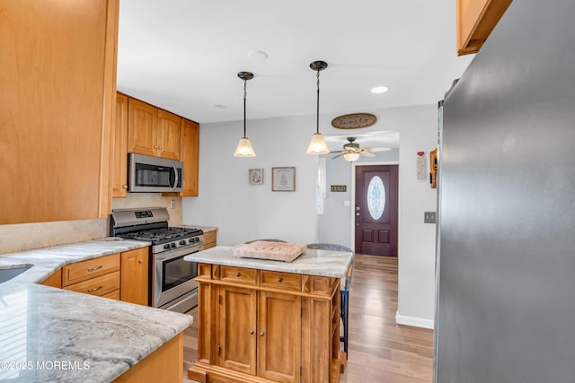 502 Corlies Ave, West Allenhurst, NJ 07711 - kitchen featuring appliances with stainless steel finishes, light wood-style flooring, ceiling fan, hanging light fixtures, and a center island