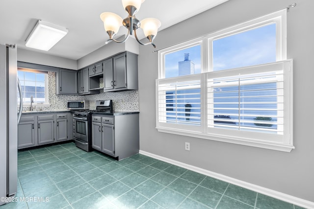 28 Greenbriar Blvd, Brick, NJ 08724 - kitchen with appliances with stainless steel finishes, gray cabinets, a chandelier, decorative backsplash, and open shelves