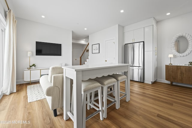33 Hamilton Ave Unit 7, Seaside Heights, NJ 08751 - kitchen with freestanding refrigerator, light wood-style flooring, a kitchen breakfast bar, white cabinets, and recessed lighting