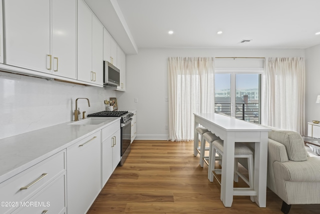 33 Hamilton Ave Unit 7, Seaside Heights, NJ 08751 - kitchen with appliances with stainless steel finishes, recessed lighting, white cabinetry, light wood-style flooring, and light countertops