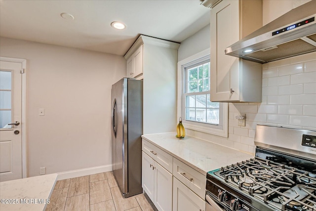 296 High St, Metuchen, NJ 08840 - kitchen with appliances with stainless steel finishes, wall chimney range hood, tasteful backsplash, light stone counters, and white cabinets