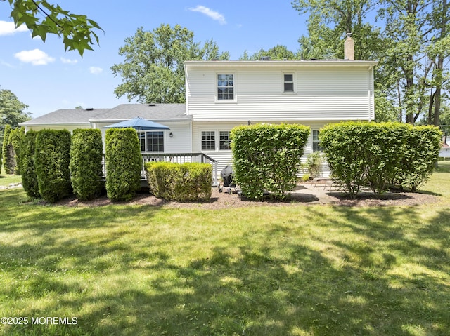 3 Thompson Ln, Manalapan, NJ 07726 - back of house with a chimney, a lawn, and a deck