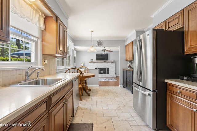 3 Thompson Ln, Manalapan, NJ 07726 - kitchen with appliances with stainless steel finishes, a fireplace with raised hearth, decorative backsplash, stone tile floors, and ornamental molding