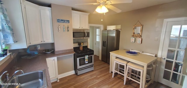412 Park Place Ave, Bradley Beach, NJ 07720 - kitchen with appliances with stainless steel finishes, a ceiling fan, white cabinetry, and light wood-style flooring