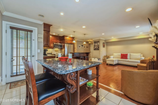 1111 Wellington Pl, Matawan, NJ 07747 - kitchen featuring stainless steel appliances, ornamental molding, light tile patterned flooring, a breakfast bar area, and a kitchen island