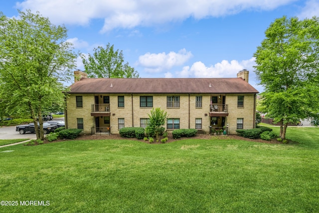 1111 Wellington Pl, Matawan, NJ 07747 - view of front facade with a balcony, a chimney, and a front yard