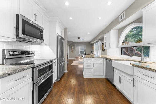 280 Double Creek Pkwy, Freehold, NJ 07728 - kitchen with appliances with stainless steel finishes, a peninsula, recessed lighting, white cabinetry, and dark wood-type flooring