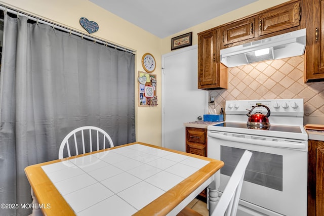 530B Sheffield Dr, Manchester, NJ 08759 - kitchen with electric range, under cabinet range hood, tasteful backsplash, brown cabinets, and tile countertops