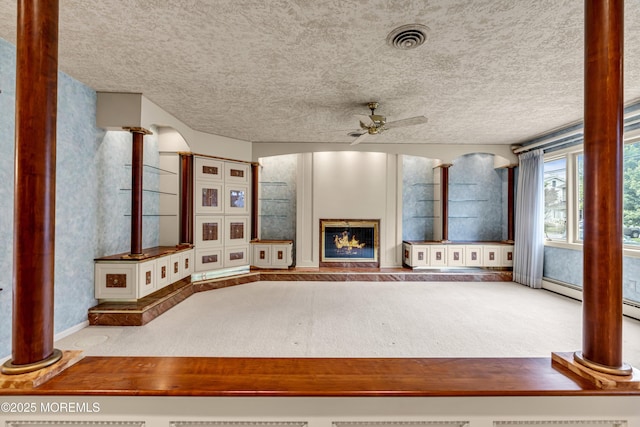 811 Fay Ct, Point Pleasant, NJ 08742 - unfurnished living room with a ceiling fan, a glass covered fireplace, carpet, a textured ceiling, and ornate columns