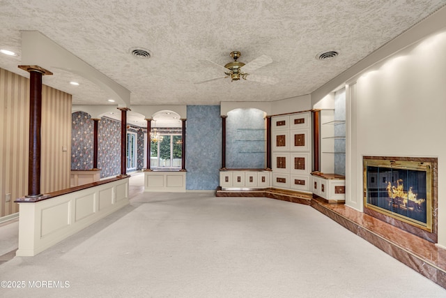 811 Fay Ct, Point Pleasant, NJ 08742 - unfurnished living room with carpet flooring, a ceiling fan, a glass covered fireplace, wallpapered walls, and decorative columns