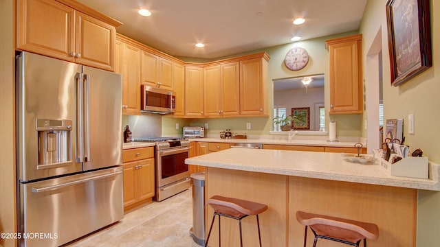 56 W Aspen Way, Aberdeen, NJ 07747 - kitchen featuring stainless steel appliances, light countertops, a kitchen bar, recessed lighting, and light brown cabinetry