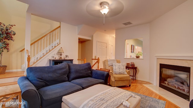 56 W Aspen Way, Aberdeen, NJ 07747 - living room with light wood finished floors, ceiling fan, stairs, and a fireplace with flush hearth
