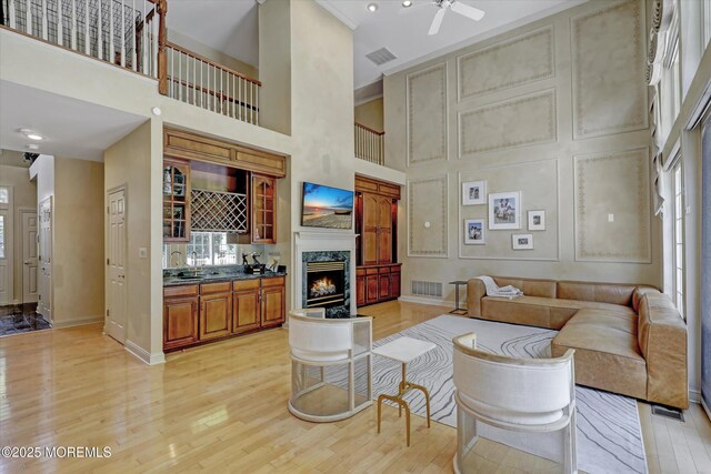 26 Bruns Rd, Allenhurst, NJ 07711 - living area featuring healthy amount of natural light, light wood-style floors, a high ceiling, a premium fireplace, and ceiling fan