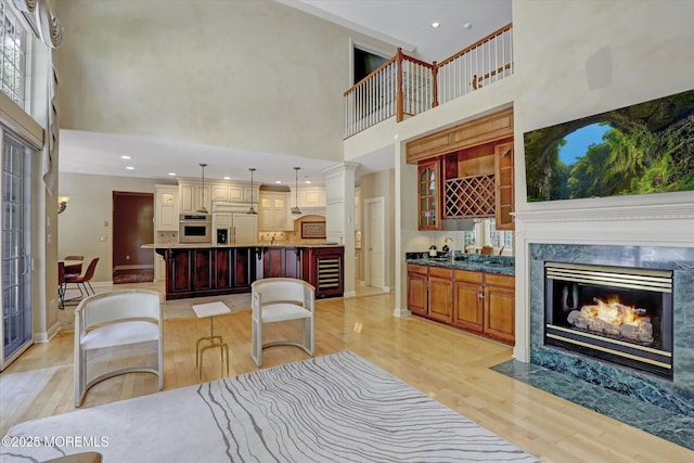 26 Bruns Rd, Allenhurst, NJ 07711 - living area with a towering ceiling, light wood-style floors, beverage cooler, a fireplace, and recessed lighting