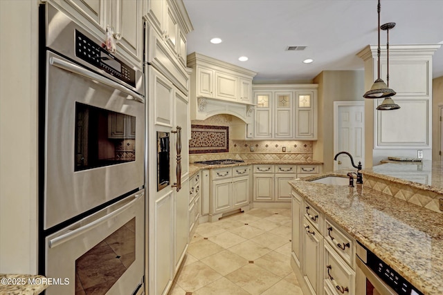 26 Bruns Rd, Allenhurst, NJ 07711 - kitchen with appliances with stainless steel finishes, cream cabinetry, backsplash, hanging light fixtures, and light stone counters