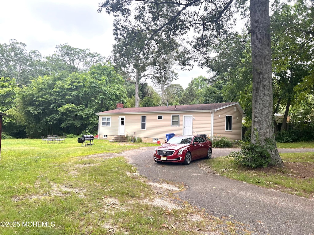 179 Maple Ave, Island Heights, NJ 08732 - view of front facade featuring a front lawn, a chimney, and asphalt driveway