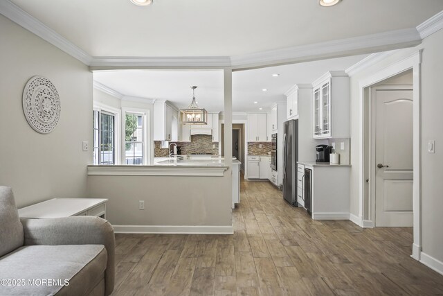 304 Mackenzie Dr, Jackson, NJ 08527 - kitchen with glass insert cabinets, ornamental molding, white cabinetry, a chandelier, and a peninsula