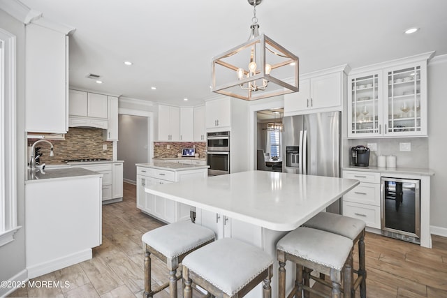 304 Mackenzie Dr, Jackson, NJ 08527 - kitchen with beverage cooler, a kitchen island, stainless steel appliances, a chandelier, and tasteful backsplash