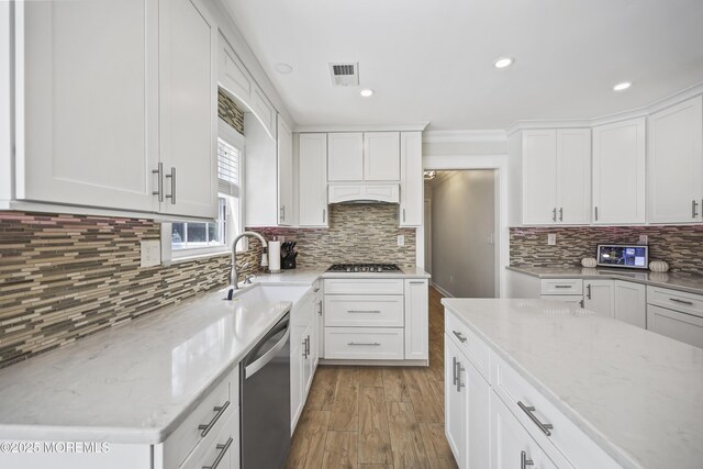 304 Mackenzie Dr, Jackson, NJ 08527 - kitchen featuring appliances with stainless steel finishes, light stone countertops, light wood finished floors, decorative backsplash, and white cabinets