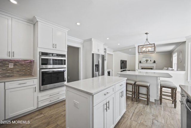 304 Mackenzie Dr, Jackson, NJ 08527 - kitchen featuring stainless steel appliances, a center island, ornamental molding, recessed lighting, and white cabinetry