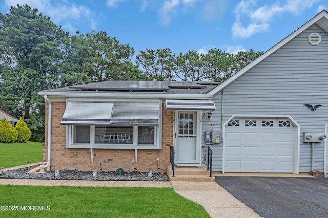 14A Portsmouth St, Whiting, NJ 08759 - view of front of house with brick siding, roof mounted solar panels, driveway, an attached garage, and a front yard