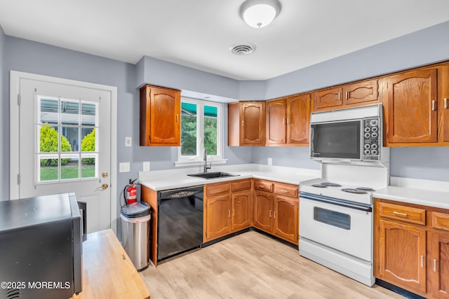 14A Portsmouth St, Whiting, NJ 08759 - kitchen featuring black dishwasher, white electric stove, light countertops, light wood finished floors, and brown cabinetry