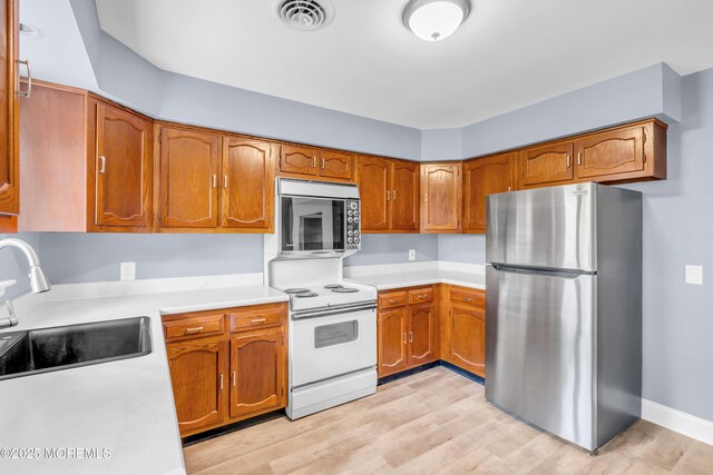 14A Portsmouth St, Whiting, NJ 08759 - kitchen featuring appliances with stainless steel finishes, brown cabinetry, light countertops, and light wood-type flooring