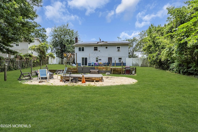 886 Stafford Dr, Toms River, NJ 08753 - back of property featuring roof mounted solar panels, a wooden deck, a fenced backyard, a chimney, and a vegetable garden