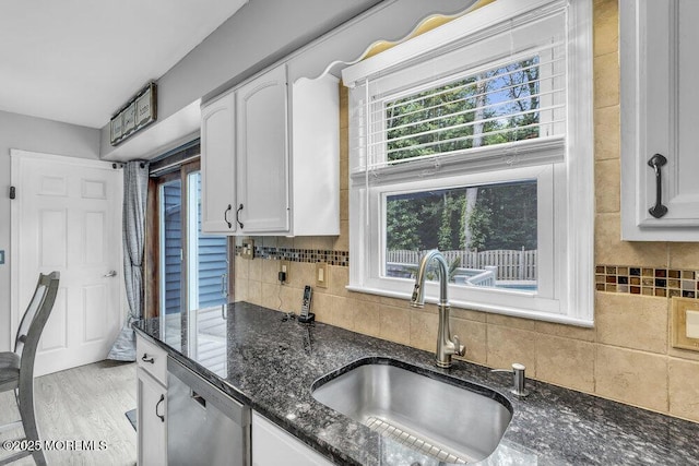 19 Bartlett Ct, Matawan, NJ 07747 - kitchen featuring stainless steel dishwasher, white cabinets, dark stone countertops, tasteful backsplash, and light wood-style floors