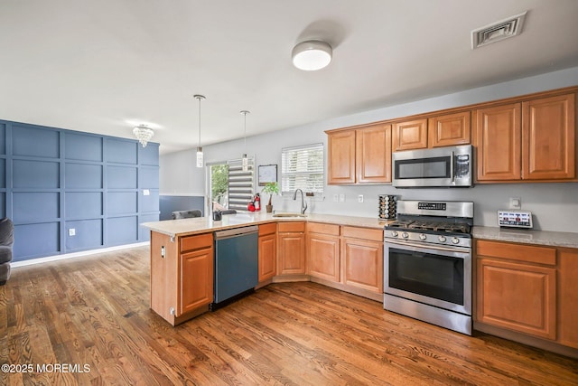 18 4th Ave, Toms River, NJ 08757 - kitchen featuring appliances with stainless steel finishes, a peninsula, dark wood-style flooring, and light countertops