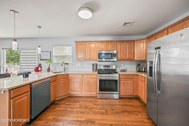 18 4th Ave, Toms River, NJ 08757 - kitchen featuring stainless steel appliances, a peninsula, wood finished floors, pendant lighting, and light stone countertops