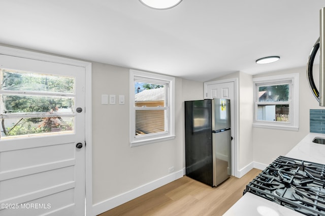 626 Clark Ave, Union Beach, NJ 07735 - kitchen featuring freestanding refrigerator, light wood-style floors, cooktop, light stone counters, and white cabinetry