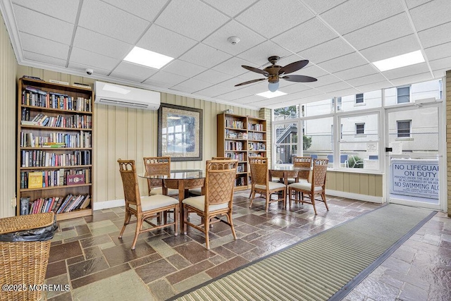 510 Deal Lake Dr Unit 8F, Asbury Park, NJ 07712 - dining area featuring a wall mounted air conditioner, ceiling fan, a paneled ceiling, ornamental molding, and stone tile flooring