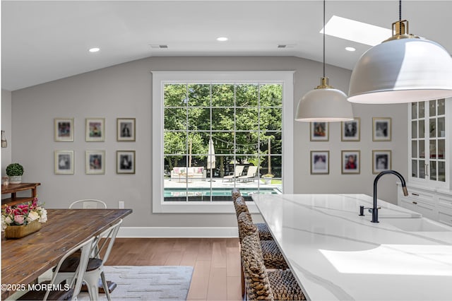 6 Buttonwood Dr, Shrewsbury Boro, NJ 07702 - kitchen with lofted ceiling, wood finished floors, light stone counters, pendant lighting, and recessed lighting