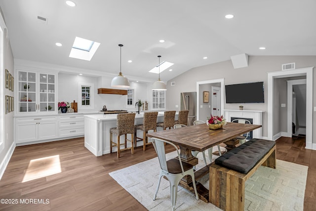 6 Buttonwood Dr, Shrewsbury Boro, NJ 07702 - dining room featuring a skylight, light wood-style floors, lofted ceiling, recessed lighting, and a fireplace