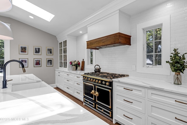 6 Buttonwood Dr, Shrewsbury Boro, NJ 07702 - kitchen featuring double oven range, vaulted ceiling, custom exhaust hood, a skylight, and tasteful backsplash