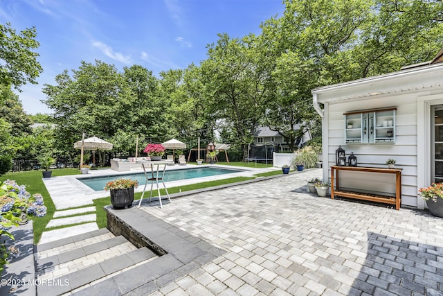 6 Buttonwood Dr, Shrewsbury Boro, NJ 07702 - swimming pool with a patio area, a trampoline, and view of scattered trees