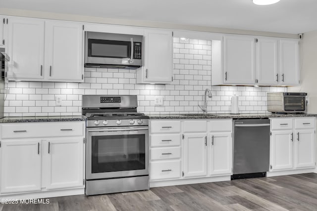 235 Willow Ln, Forked River, NJ 08731 - kitchen featuring stainless steel appliances, white cabinets, dark stone countertops, and wood finished floors