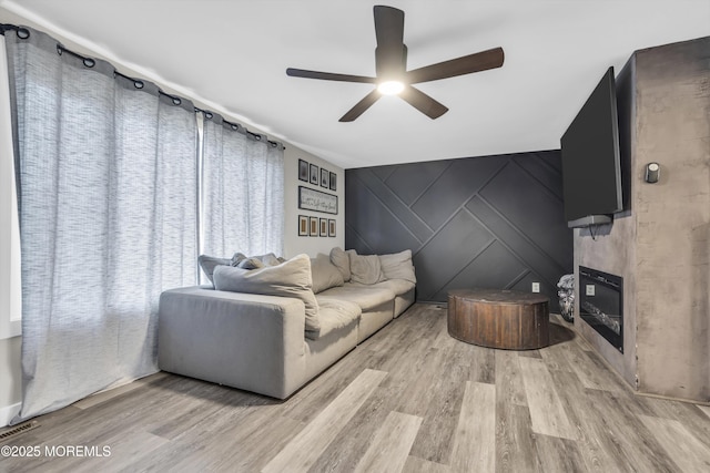235 Willow Ln, Forked River, NJ 08731 - living room with ceiling fan, wood finished floors, a decorative wall, a large fireplace, and an accent wall