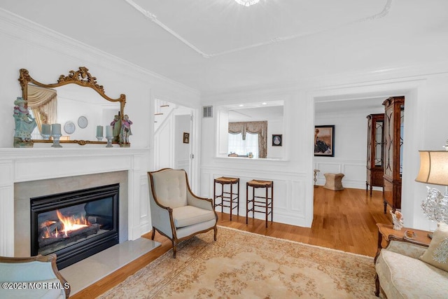1905 3rd Ave, Spring Lake, NJ 07762 - sitting room with wood finished floors, crown molding, a glass covered fireplace, stairs, and a decorative wall