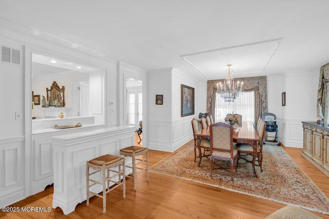 1905 3rd Ave, Spring Lake, NJ 07762 - dining area with a decorative wall, a chandelier, healthy amount of natural light, light wood finished floors, and crown molding