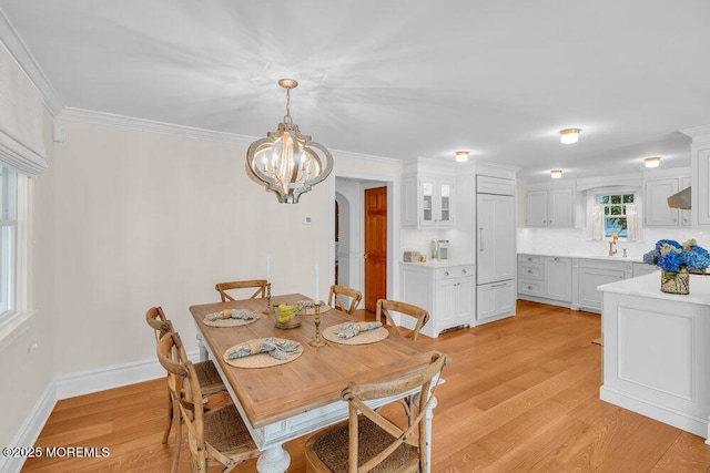 1905 3rd Ave, Spring Lake, NJ 07762 - dining area featuring light wood-type flooring, a chandelier, arched walkways, and crown molding