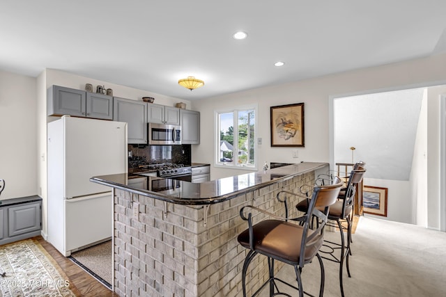 35 Tahoe Ln, Stafford, NJ 08050 - kitchen featuring appliances with stainless steel finishes, gray cabinetry, a kitchen bar, tasteful backsplash, and recessed lighting
