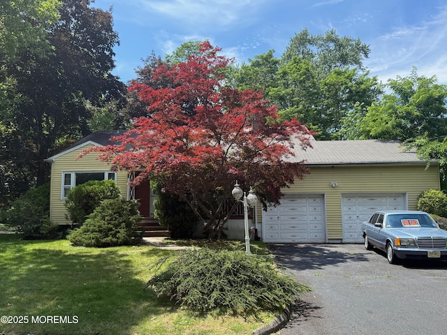 34 Woodbrook Cir, Westfield, NJ 07090 - view of property hidden behind natural elements with driveway, a garage, and a front lawn