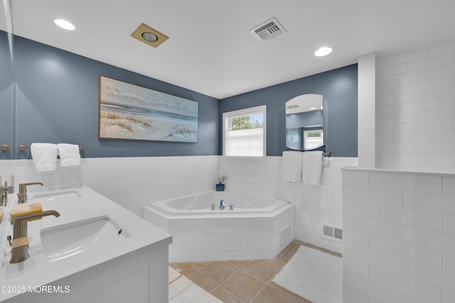 12 Diane Dr, Brick, NJ 08724 - bathroom featuring a garden tub, double vanity, tile patterned flooring, and tile walls