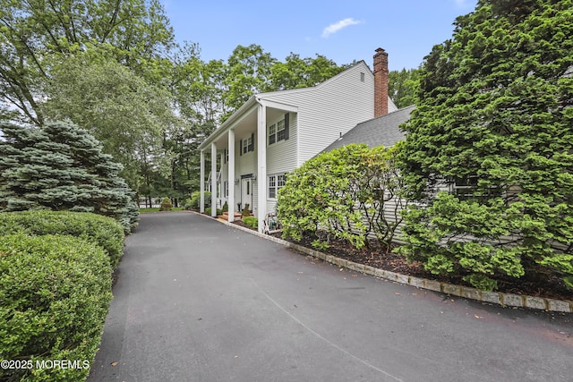 6 Stoecker Rd, Holmdel, NJ 07733 - view of side of property featuring a chimney and asphalt driveway