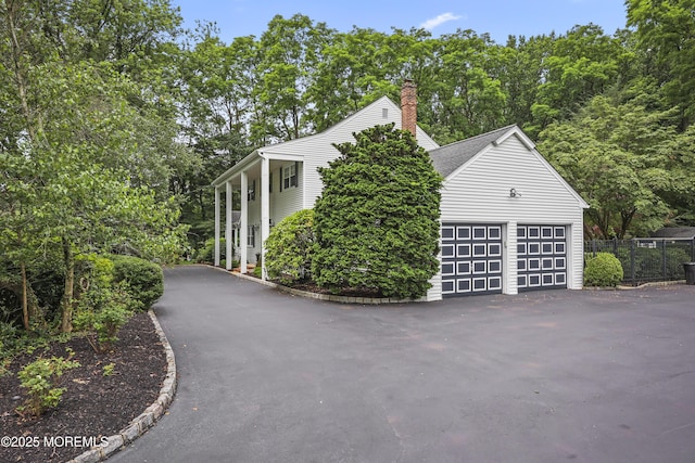 6 Stoecker Rd, Holmdel, NJ 07733 - view of side of home with a garage, a chimney, and driveway